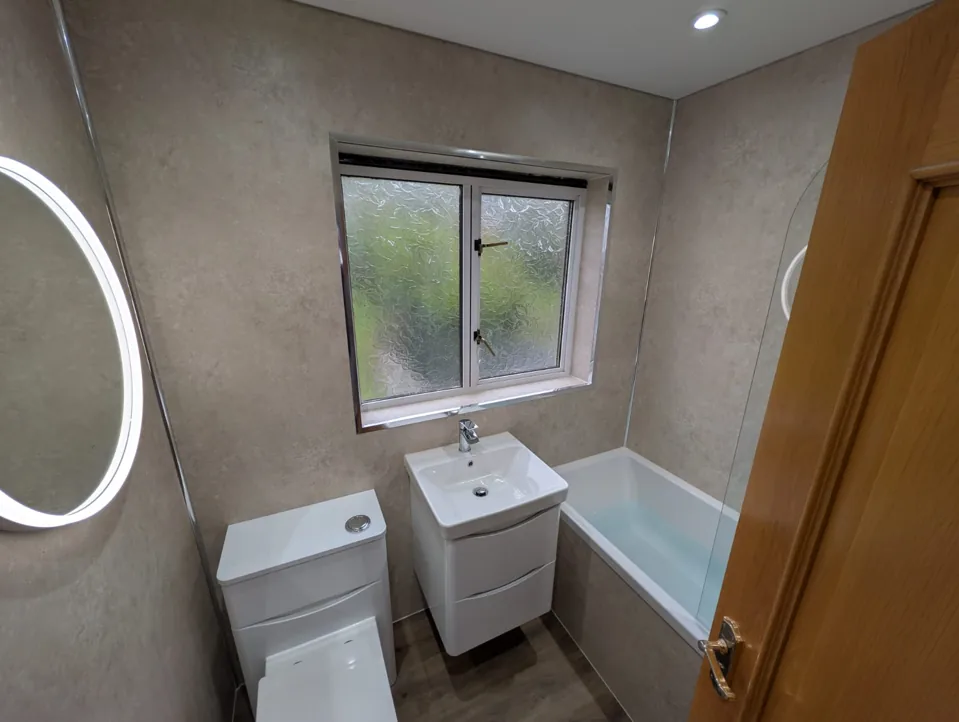 White vanity and toilet beside a fitted bath